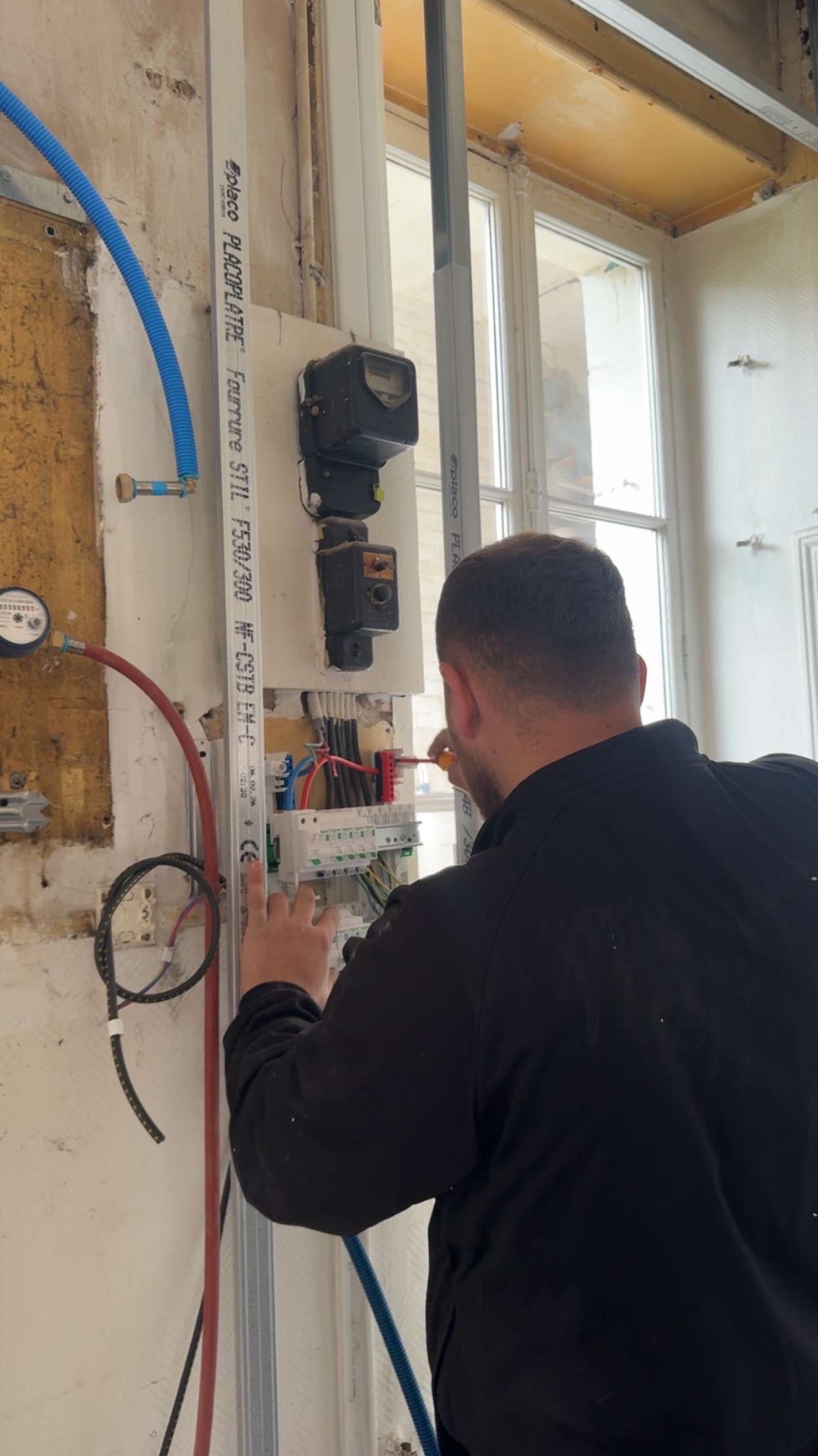 Électricien ES Électricité en train d'installer un tableau électrique